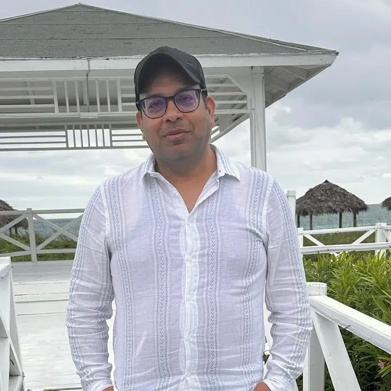 Yogesh Saini, small business owner and AI guide, standing outdoors by the water